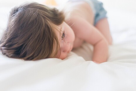 photo: baby hugging sheets