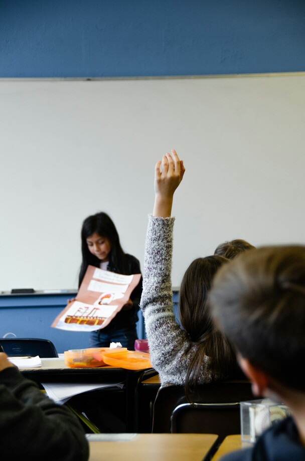 photo: elementary student raising hand in class