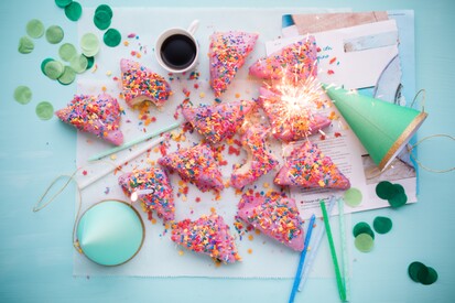 photo: birthday cake, hats, confetti, sparkler seen from above