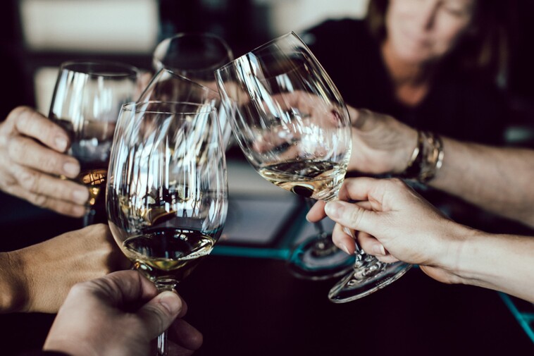 photo: several wine glasses raised together in a toast