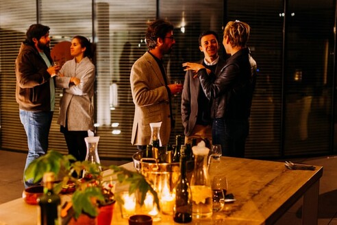 photo: people talking in small groups around food and candles