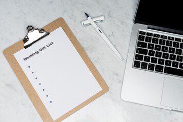 photo from above of open laptop, pen, and wedding gift list