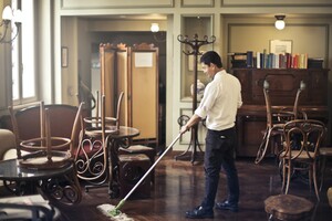 professional cleaner mopping a wooden floor in a retro-looking parlor