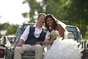 happy newlyweds sitting on the back of a truck