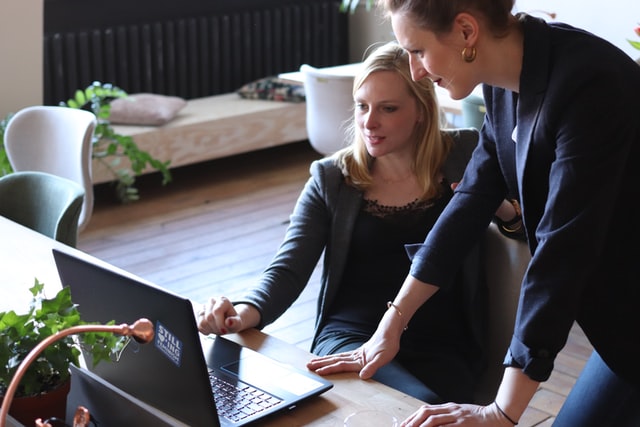 photo: two woman with about ten years age difference working together at a computer