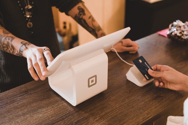 photo: credit card being handed at checkout