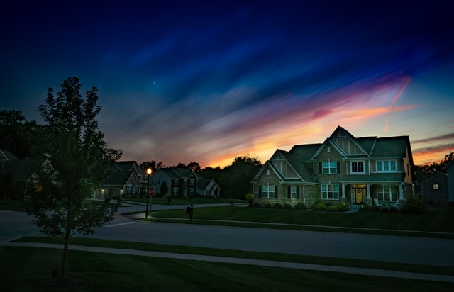 suburban family home at sunset with a divided sky framing the house with light