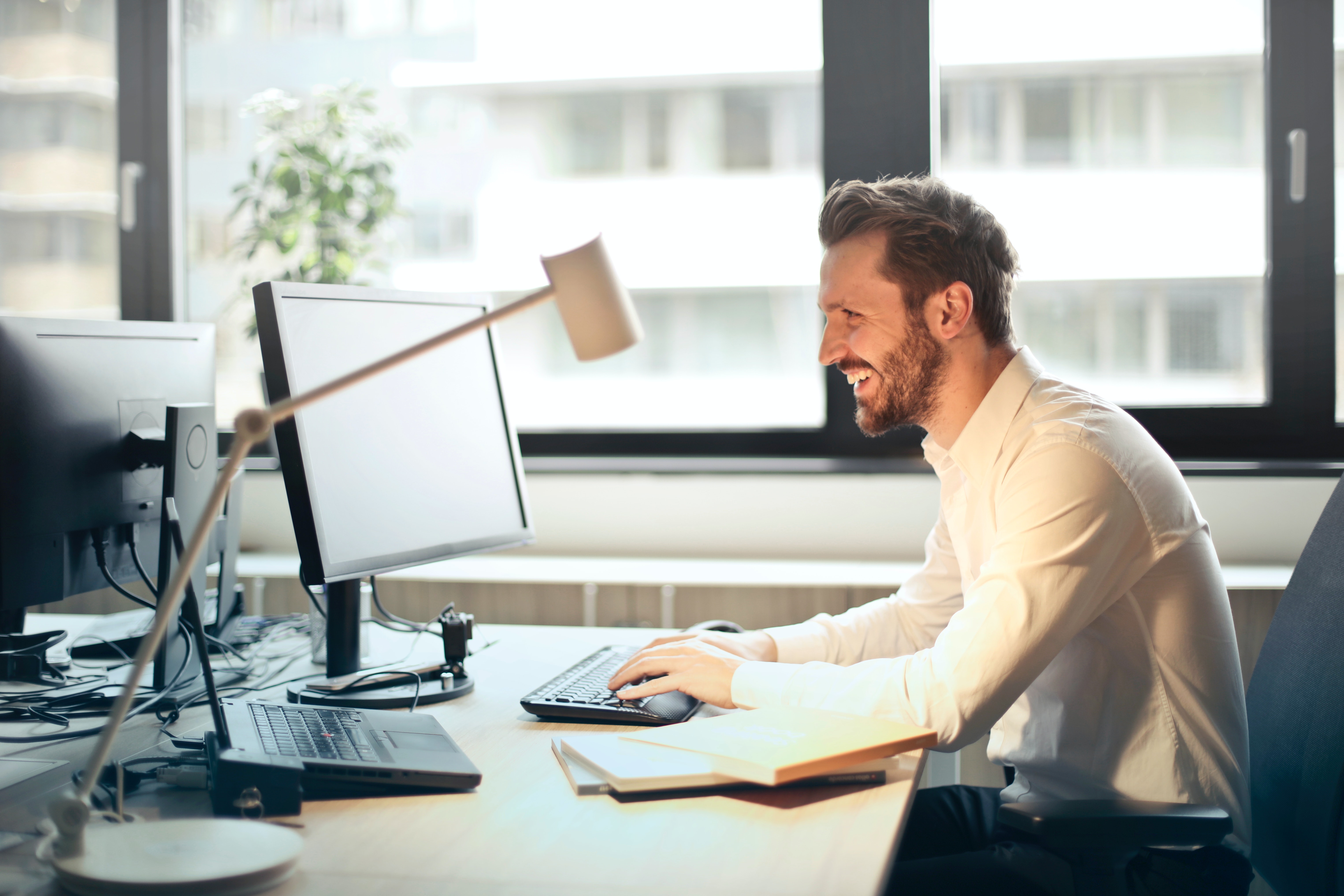 man smiling and laughing looking at his computer